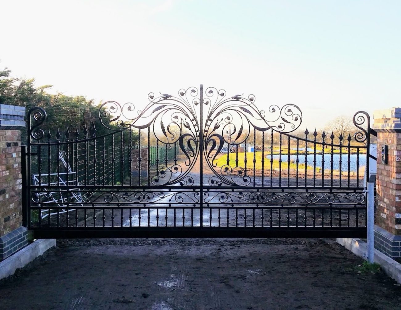 Ornate black wrought iron double gate with scrollwork