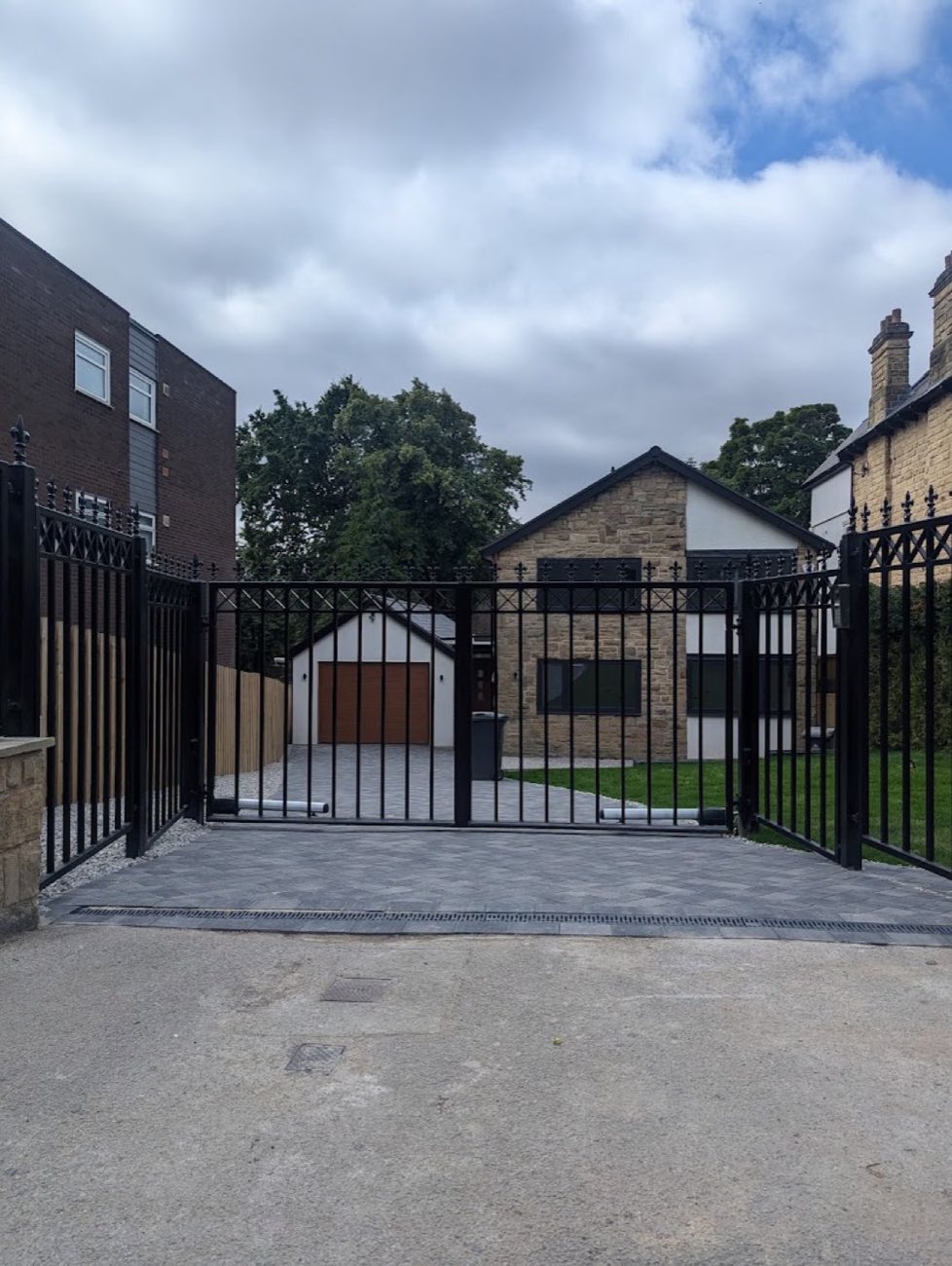 Tall black metal sliding security gate at a new-build property